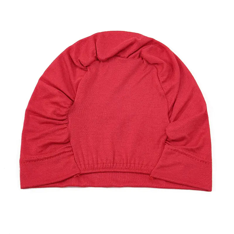 A vibrant red stretchy jersey hijab cap and turban set featuring a soft ribbed knit texture with gathered side panels.