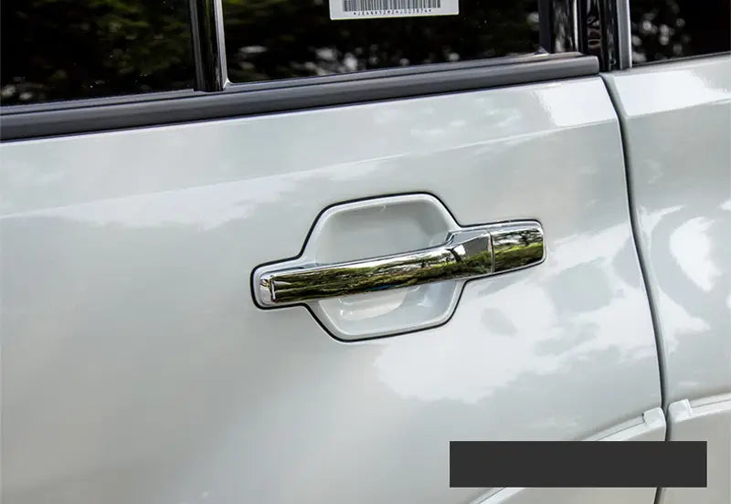 Garniture de poignée de porte en chrome avec design moderne élégant, montée sur le côté d’un véhicule Mitsubishi Pajero argenté 2007 à 2021.