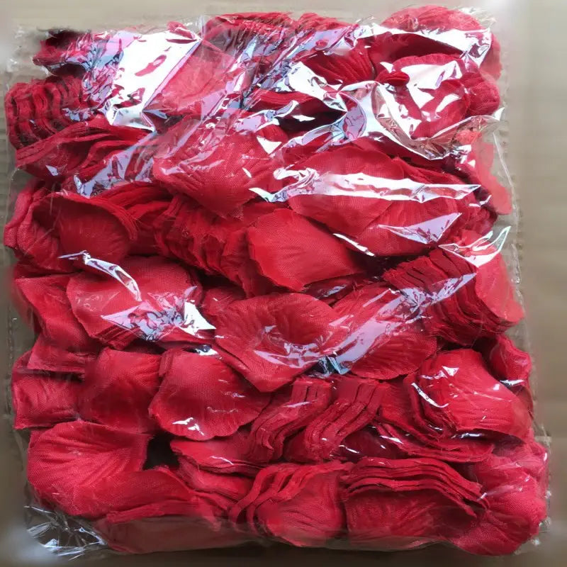 Eine leuchtend rote satinartige Stoff-Rosenblüte mit feinen Fältchen und realistischen Knicken aus der Kollektion „5500 bunte Rosenblüten“ zur Hochzeitsdekoration.