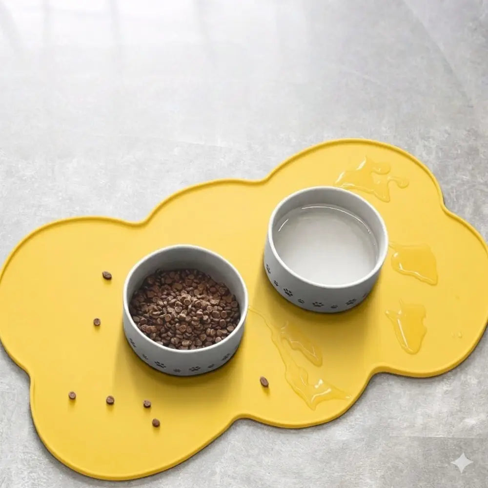 Gelbe, wolkenförmige Silikon-Futtermatte für Haustiere mit zwei grauen Pfotenabdruck-Näpfen, ausgelegt für die Fütterung von Haustieren und eine einfache Reinigung.