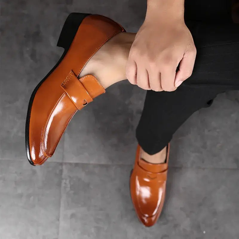 Polished tan leather men leather business dress shoes with a pointed toe and black rubber sole.