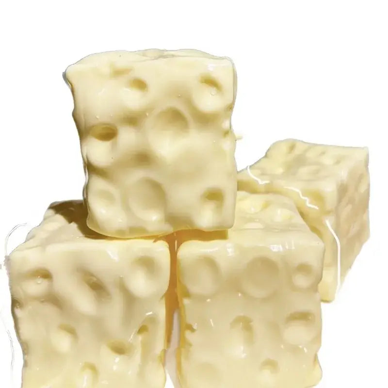 Cream-colored cube-shaped cheese block stress relief squeeze toy featuring a textured surface mimicking swiss cheese holes.