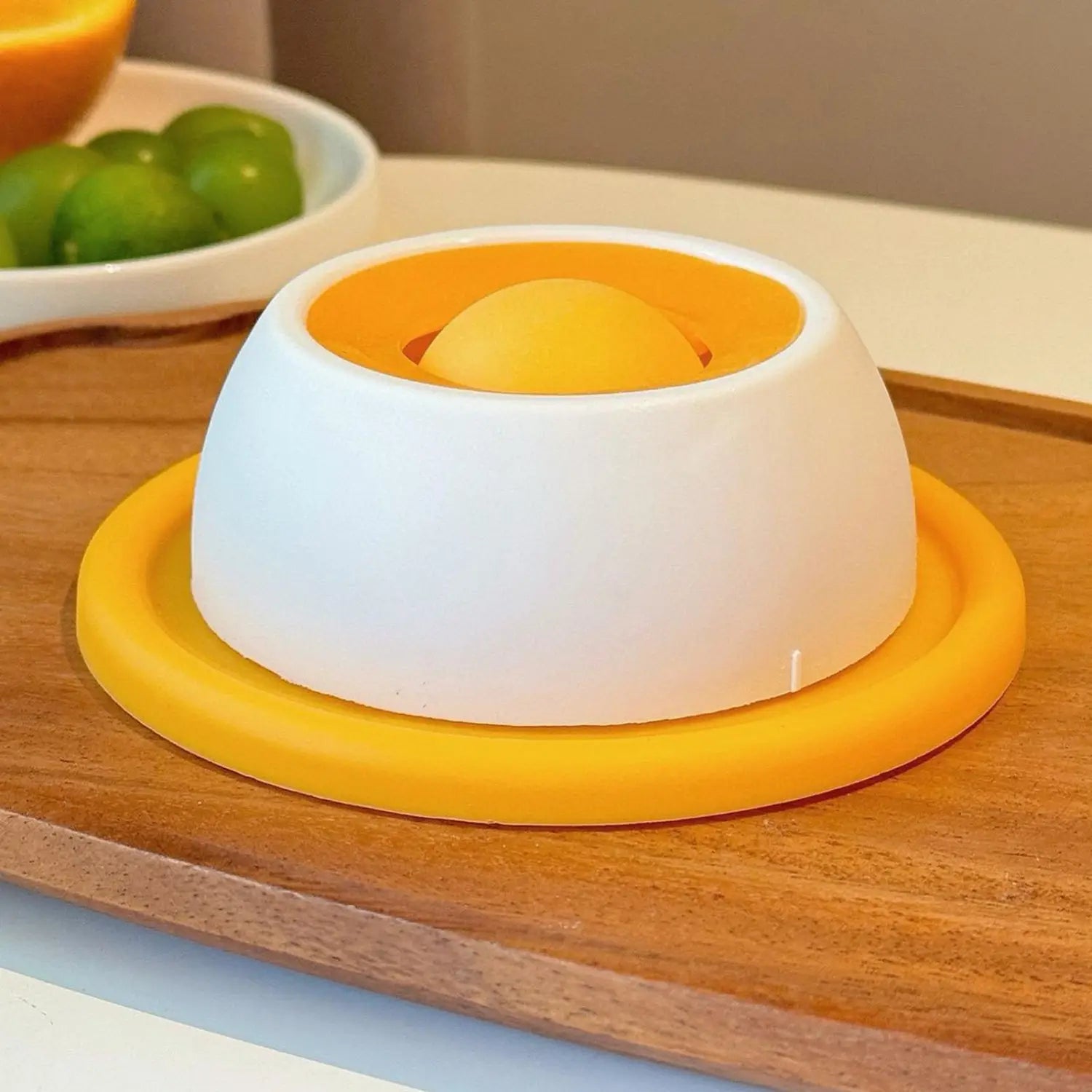 White and yellow silicone dome-shaped citrus juicer designed as a dog licking toy for slow feeder puzzle use with puppies.