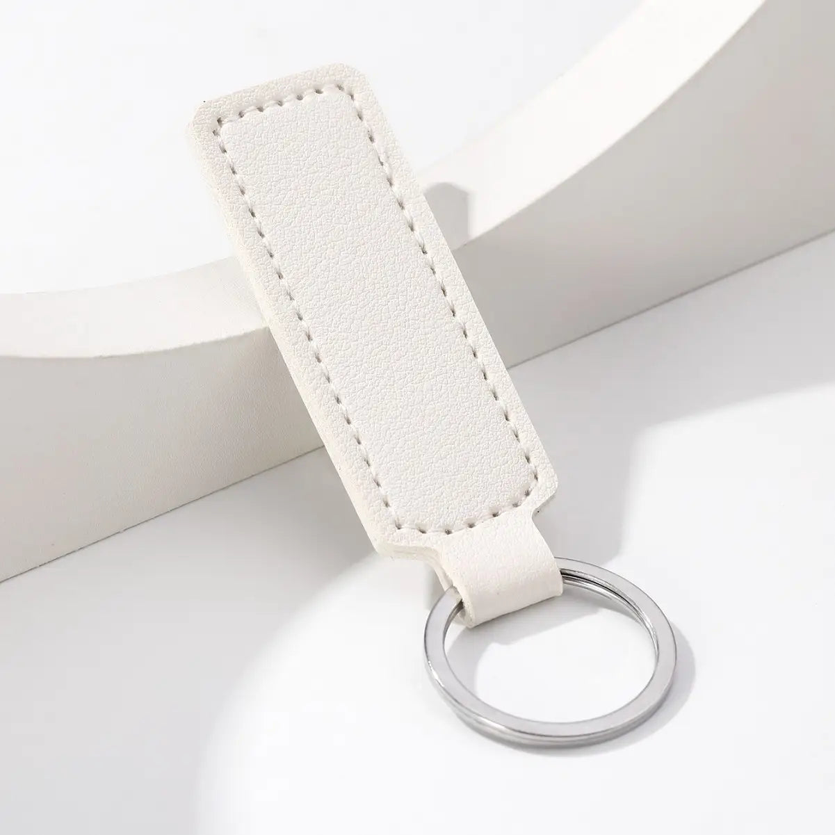 White leather minimalist strip key ring with a silver metal ring for car keys.