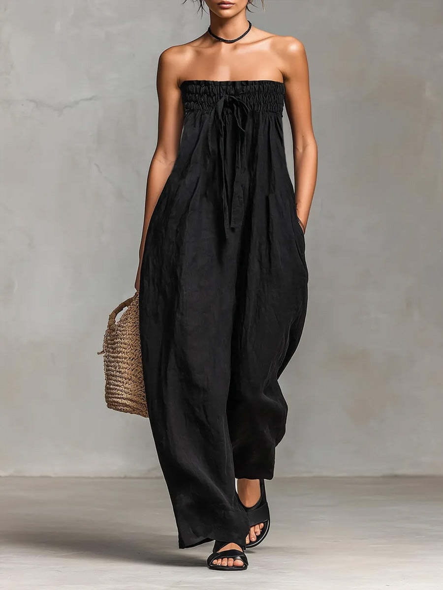 Ein schwarzes trägerloses Sommer-Jumpsuit mit weitem Bein mit geraffter Taille und Bindeband aus fließendem Stoff für Damen.