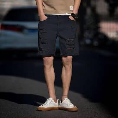 Short en denim bleu foncé avec des détails déchirés et une conception robuste décontractée, dans un style streetwear.