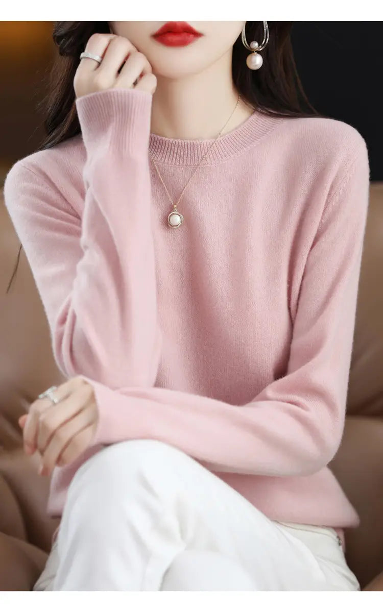 A soft pink pure wool cashmere O-neck pullover sweater with long sleeves and ribbed cuffs.