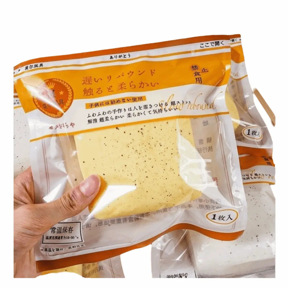 ein verpackter heller gelber gesprenkelter Schwammkuchen mit weicher Textur, der neben einem Polyester-Acryl-Winterschal platziert ist.