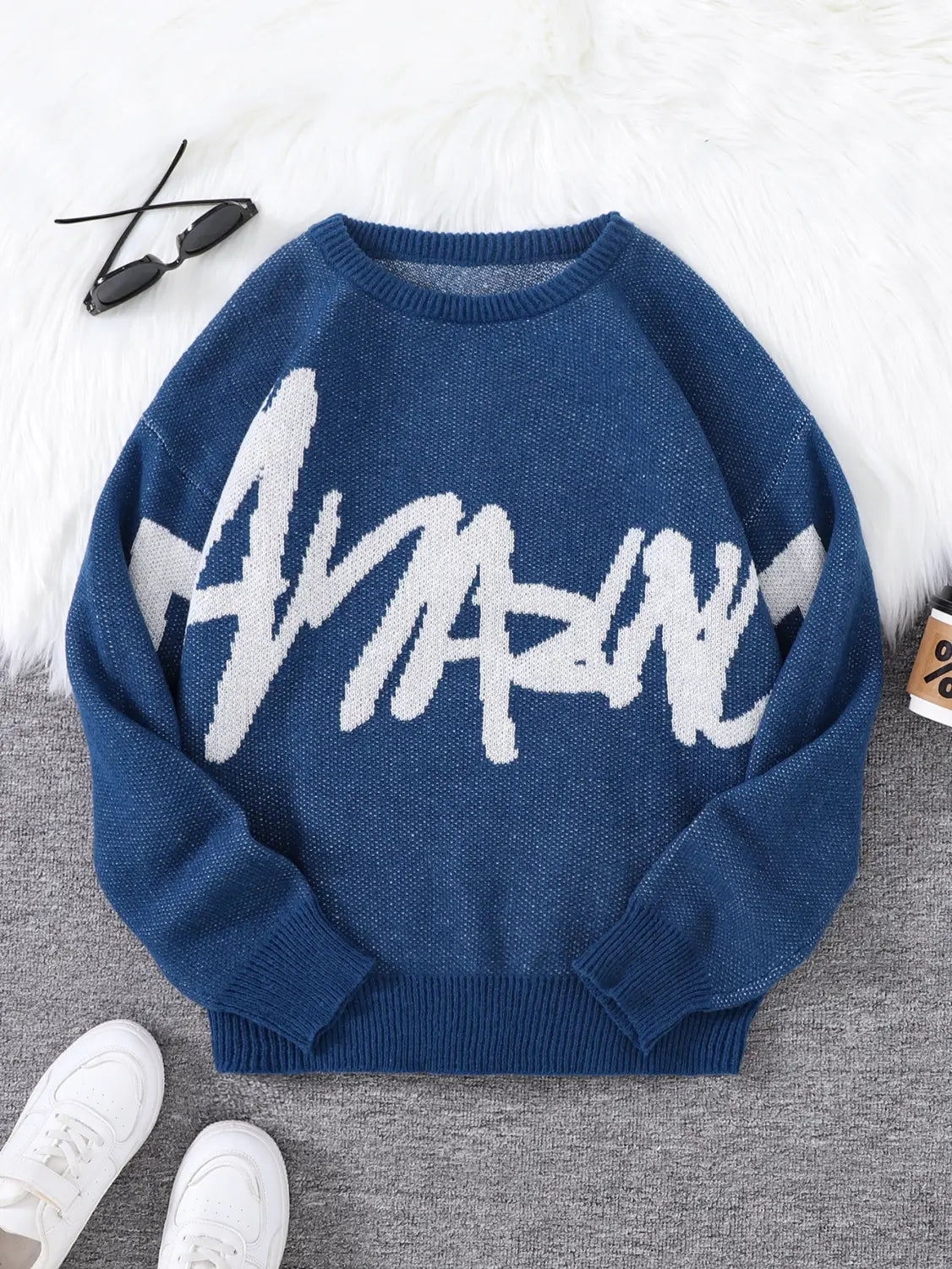 Men black knit sweater with bold white amazing lettering across the chest in blue knit fabric.