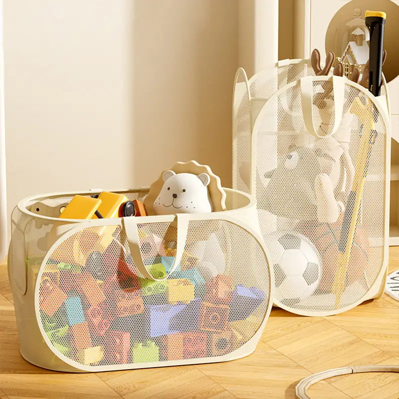 Beige mesh toy storage basket with large capacity sturdy handles and collapsible design filled with colorful toys.