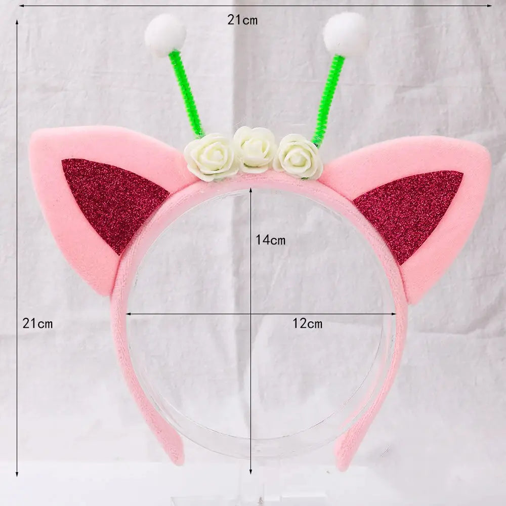 Diadema de orejas de gato color rosa con orejas internas brillantes rojas, rosas de tela blancas y antenas de limpiapipas verdes con pompones blancos esponjosos como accesorio para el cabello kawaii.