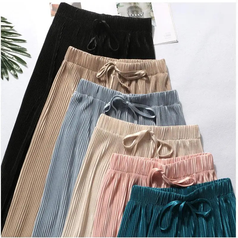 Eine Kollektion an weit geschnittenen, plissierten Sommerhosen für Damen mit elastischem Bund und Kordelzug in Schwarz, Beige, Blau, Pink und Teal.