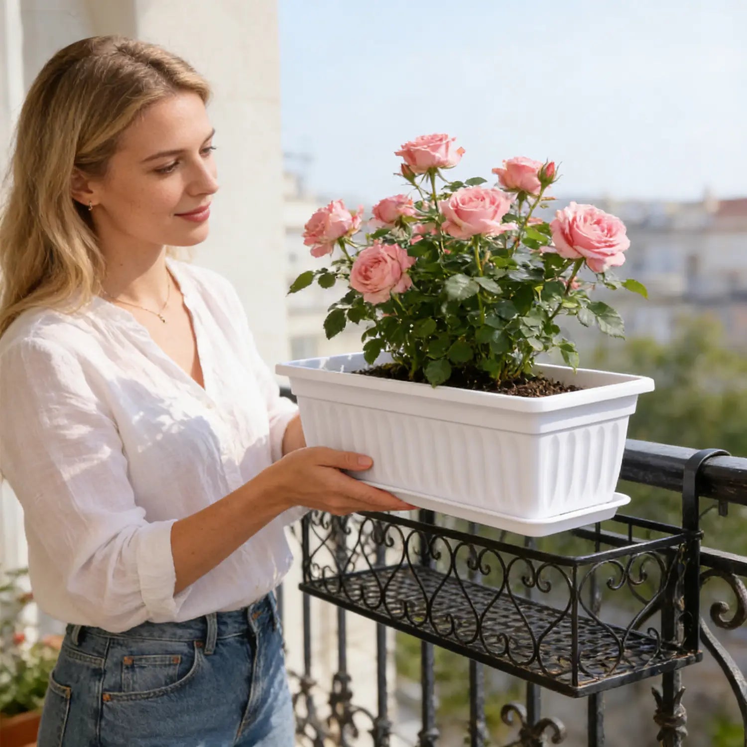 Maceta rectangular de plástico blanca con acanalados verticales que sostiene rosas rosadas, como descripción del producto de bandejas para semillas para jardinería