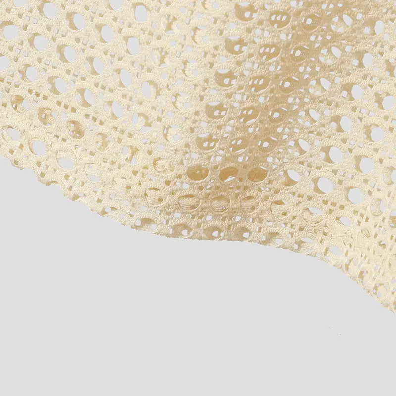 Tissu en dentelle couleur crème, avec des motifs circulaires et floraux répétitifs et complexes, sur un débardeur en maille pour hommes, chemise d’été décontractée sans manches.