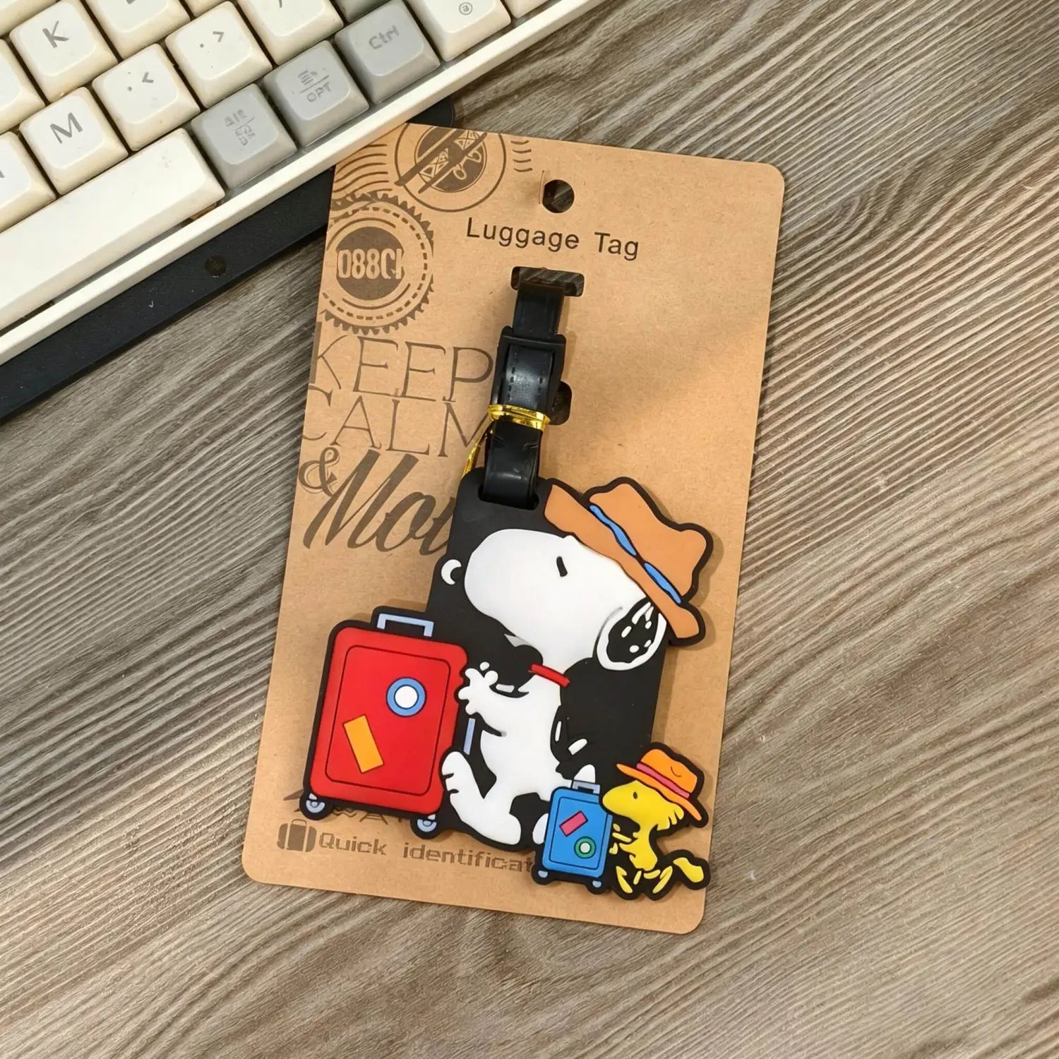 Etiqueta de equipaje de Snoopy negra de goma para identificación, con un diseño de caricatura adorable con sombrero naranja y maleta roja.