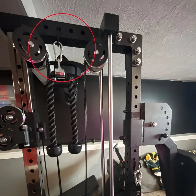 Black pulley system with metal sheaves and rope attachments for squat rack barbell storage holder attachments.