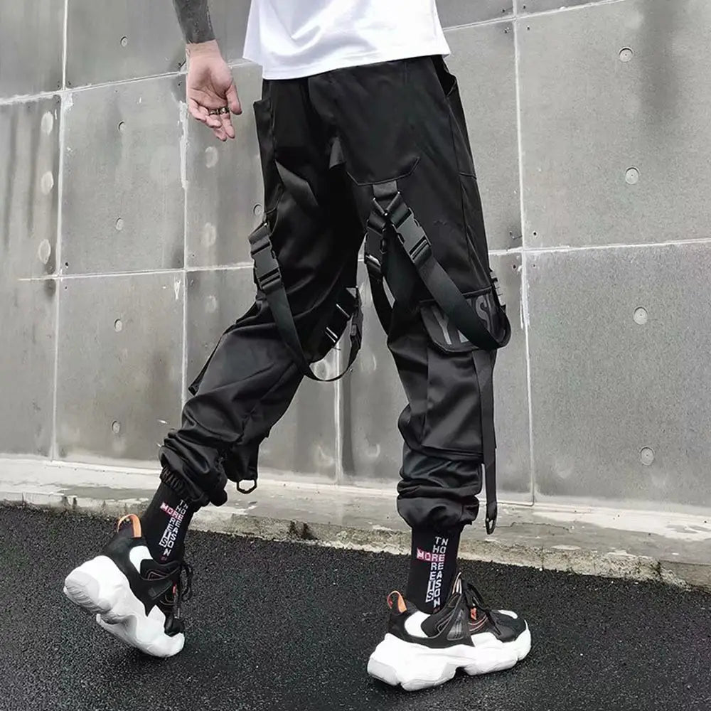 Pantalon cargo joggers streetwear pour hommes en matériau tactique noir, avec bretelles réglables et plusieurs poches, pour un usage pratique.