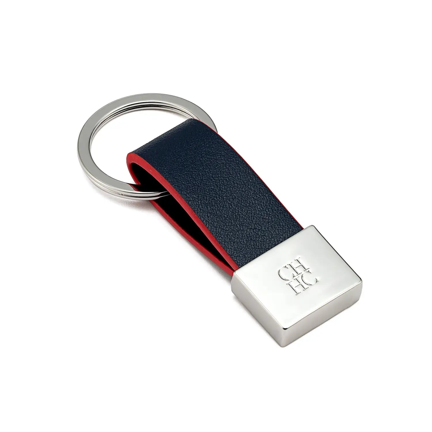 Porta llaves de cuero azul marino con forro interior rojo y una placa cuadrada de color plateado grabada con ch hc, diseñada como un accesorio de equipaje minimalista.