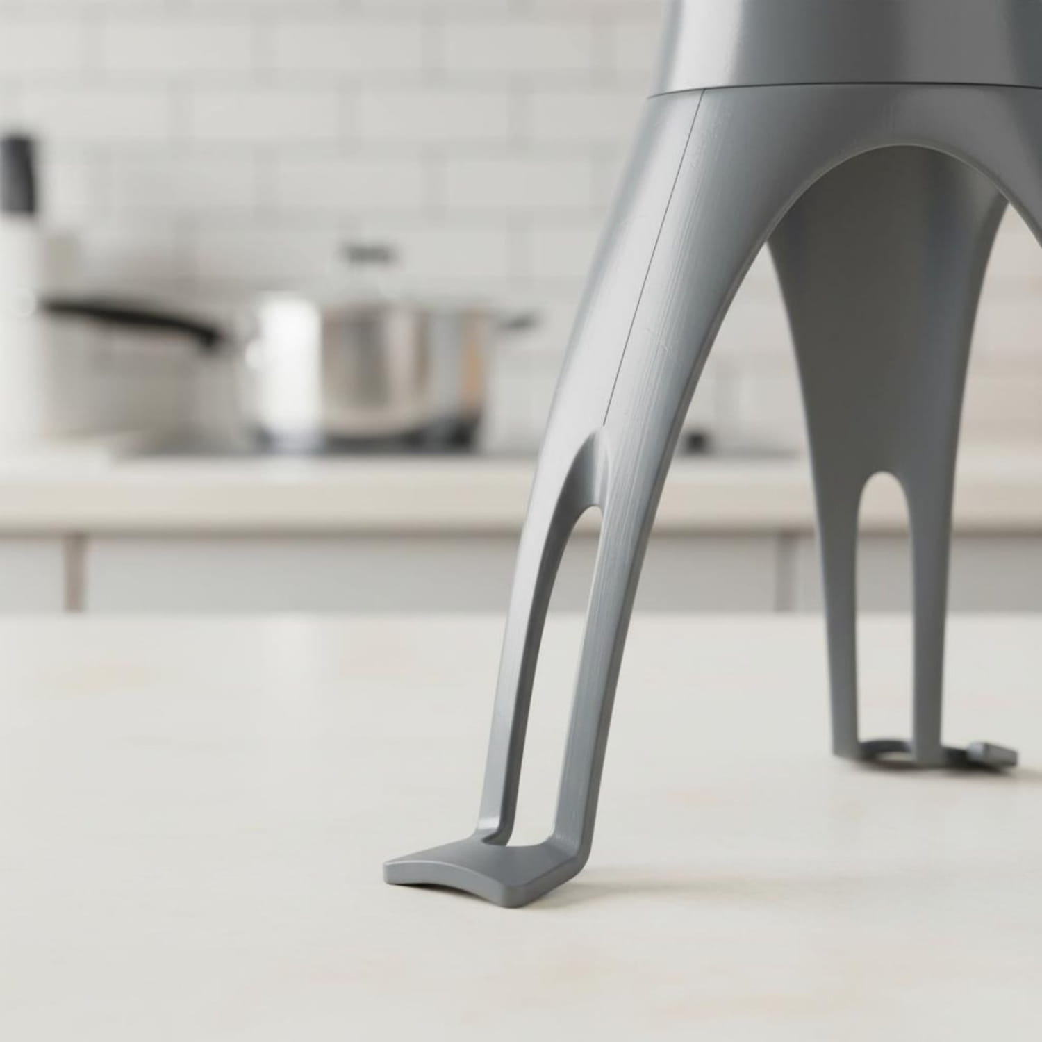 gray metallic automatic stirrer for pots and pans with sleek curved three-leg pan stirrer design and modern construction