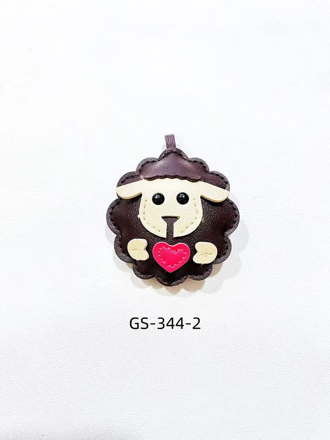 Leather sheep keychain featuring a cute brown leather charm with a cream-colored face and a pink heart bag charm.