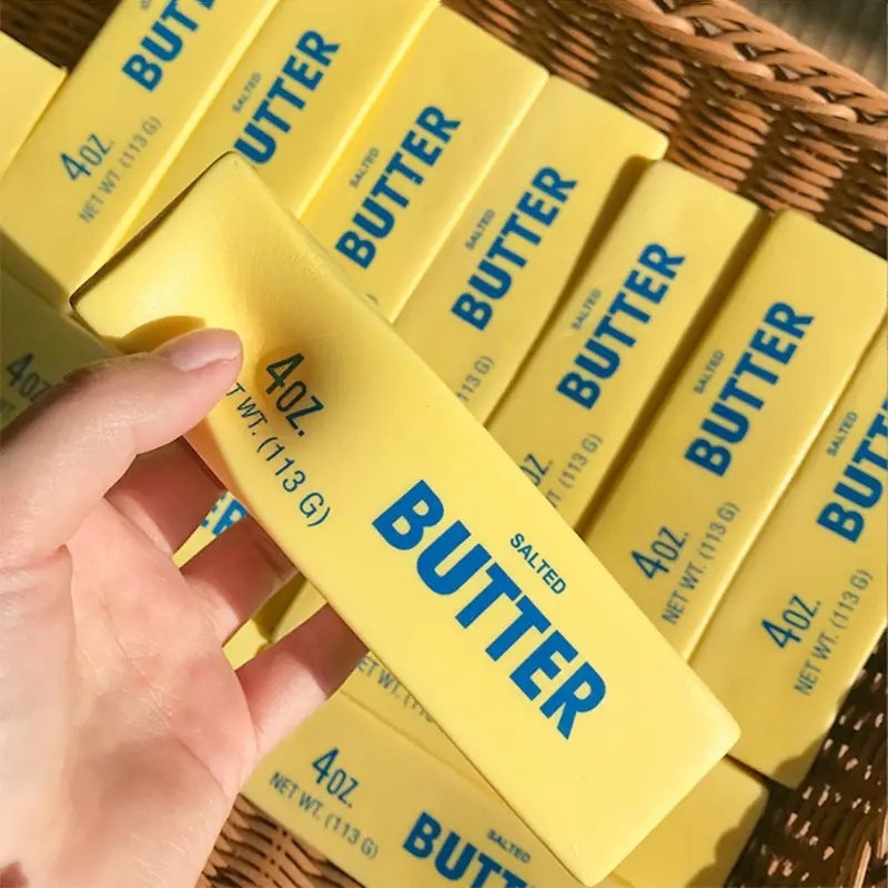 yellow salted butter stick stress relief toy featuring bold blue lettering and a classic rectangular design resembling grocery store butter sticks