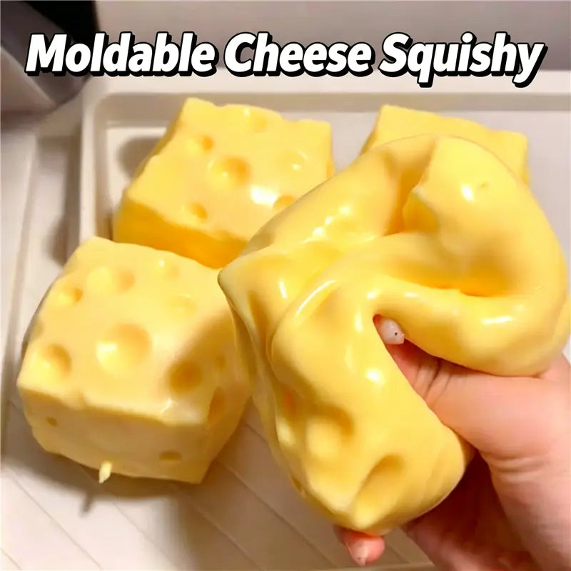 Jouet sensoriel de type balle anti-stress en forme d’arachide, fabriqué dans une matière jaune déformable en forme de fromage, souple, avec des perforations caractéristiques et une surface brillante.