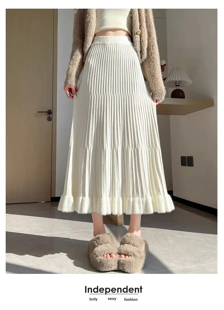 Jupe mi-longue en maille couleur crème, à taille haute, design parapluie à plis et texture duveteuse douce, présentant un ourlet en étages.