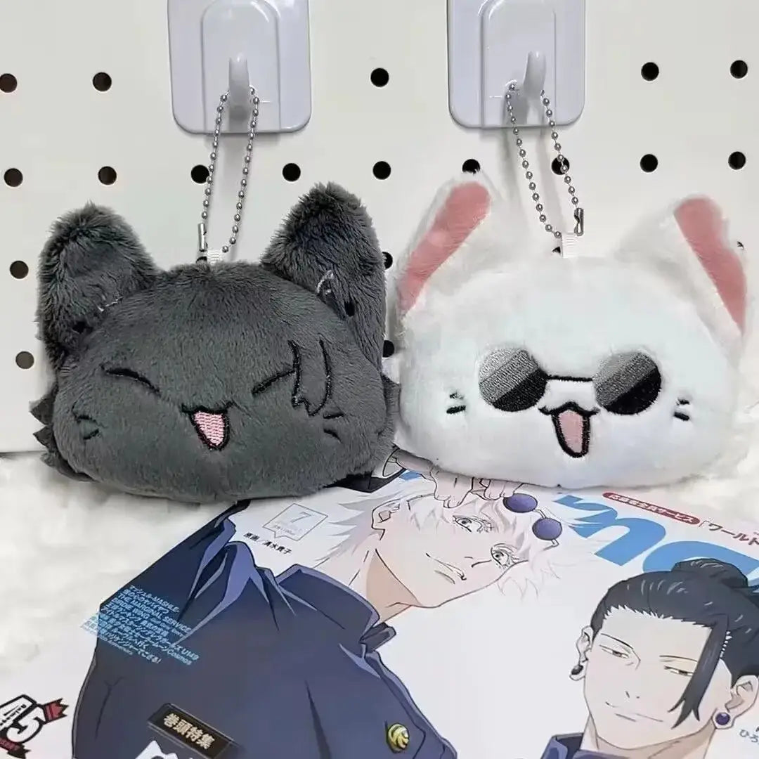 Gray and white plush Gojo and Geto cat anime keychains with embroidered facial features and metal ball chains.