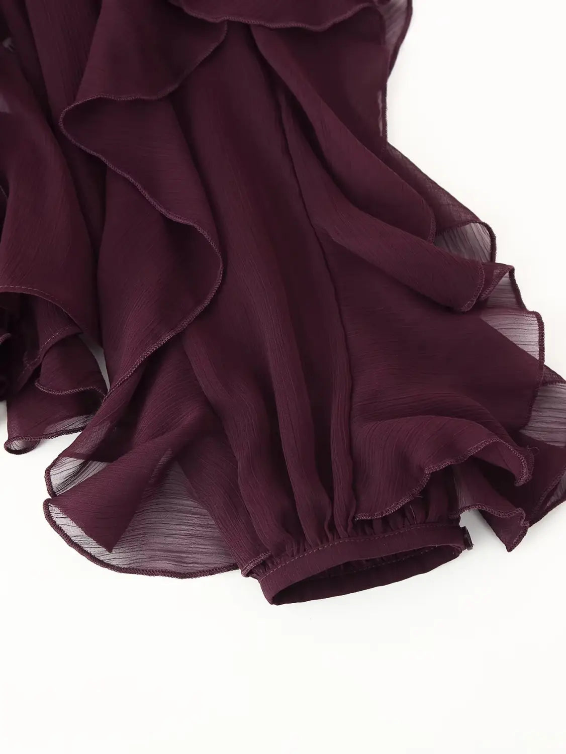 a flowing deep burgundy chiffon skirt with delicate ruffled layers and a softly gathered hem paired with a long sleeve ruffle shirt long v-neck chiffon blouse