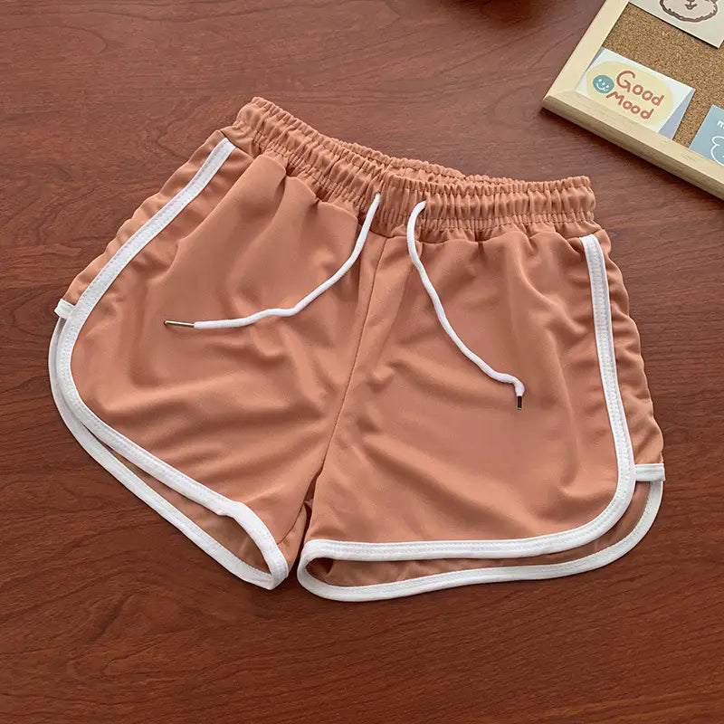 women casual athletic shorts featuring tan fabric with white trim and adjustable drawstring for a comfortable fit