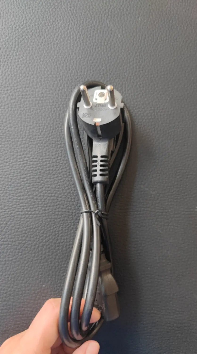 black coiled power cord with a three-prong european-style plug shown on the back side of a horse riding exercise machine fitness equipment.