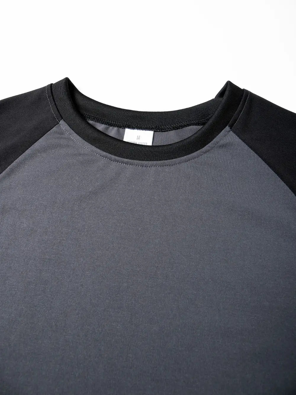 Herren-Raglanshirt mit langem Ärmel, mit schwarzen und anthrazitgrauen Raglanärmeln und geripptem Rundhals-Design.