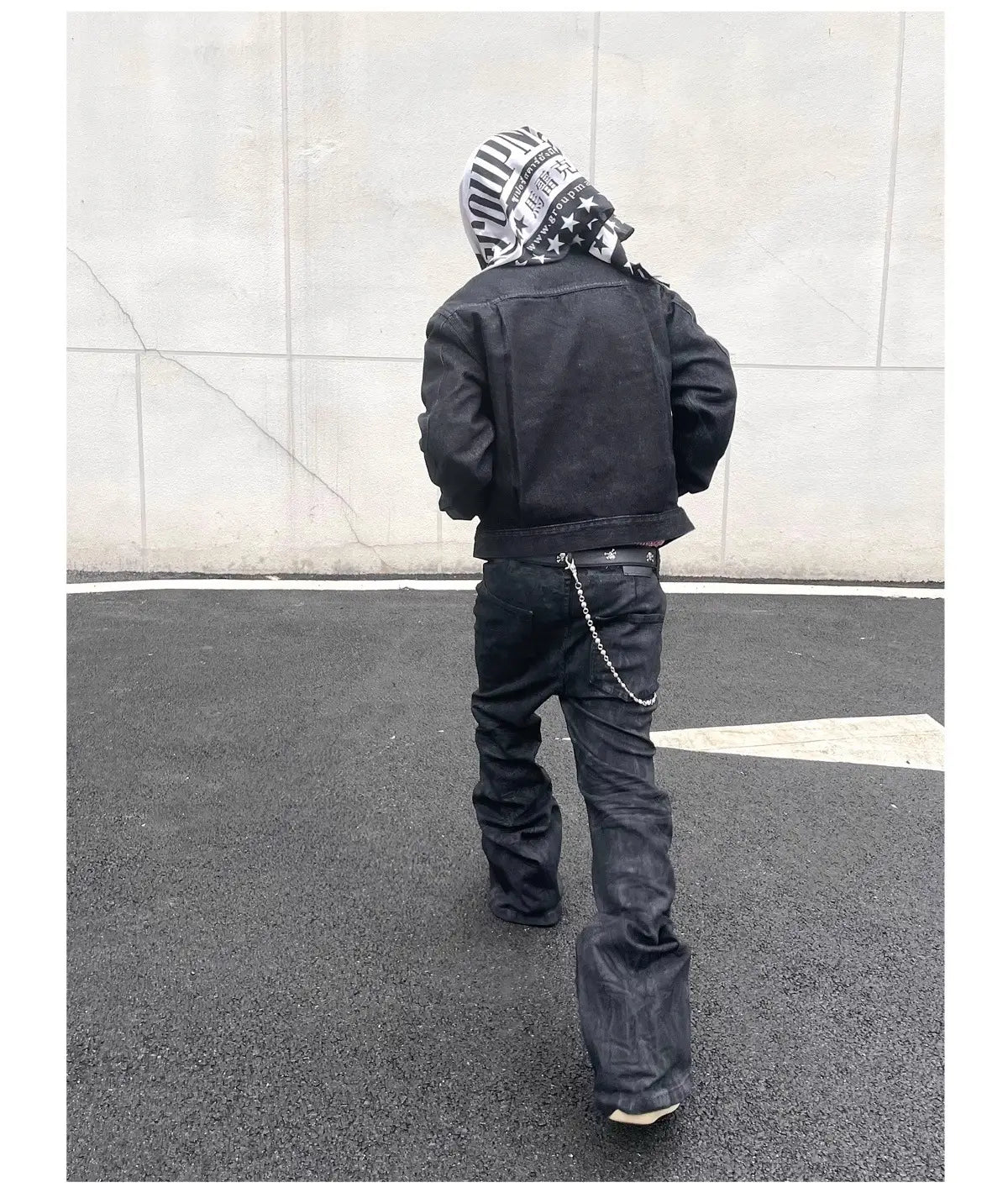 Veste en denim noire présentant un détail de boucle de ceinture avec chaîne, associée à des jeans empilés en denim noir Y2k vintage pour hommes