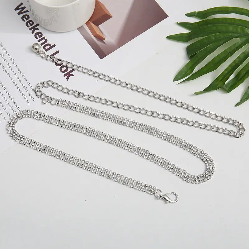 Silver rhinestone chain belt for women featuring a double row of sparkling rhinestones and an adjustable lobster clasp metal waist accessory.