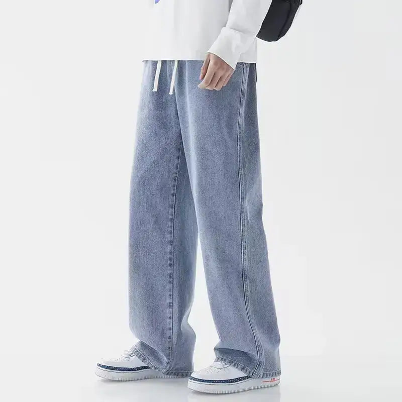 Jeans en denim Y2K à jambes larges et ample pour hommes en denim clair, coupe décontractée et taille à cordon de serrage blanc.