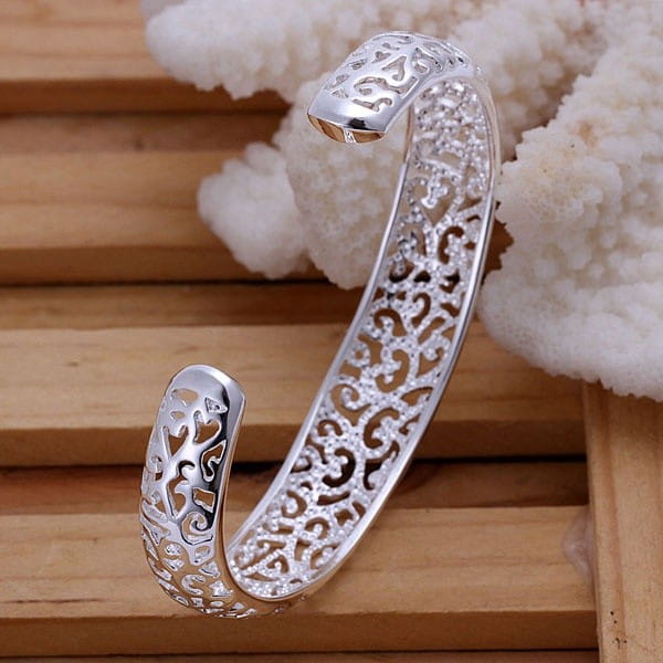 Sterling silver filigree cuff bracelet featuring a silver open-ended design with intricate filigree and embedded clear crystals.