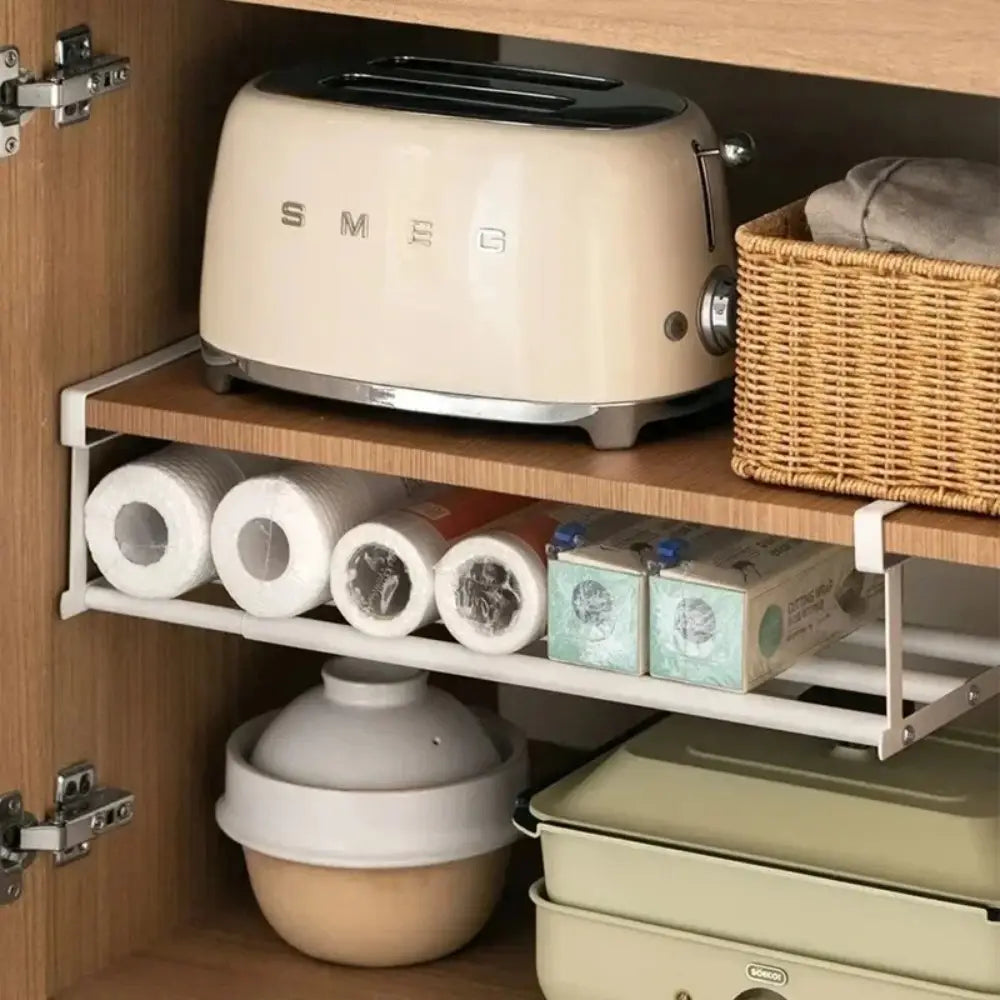 Cream-colored smeg toaster with a sleek retro design and chrome accents displayed alongside a telescopic shoe rack metal storage organizer.