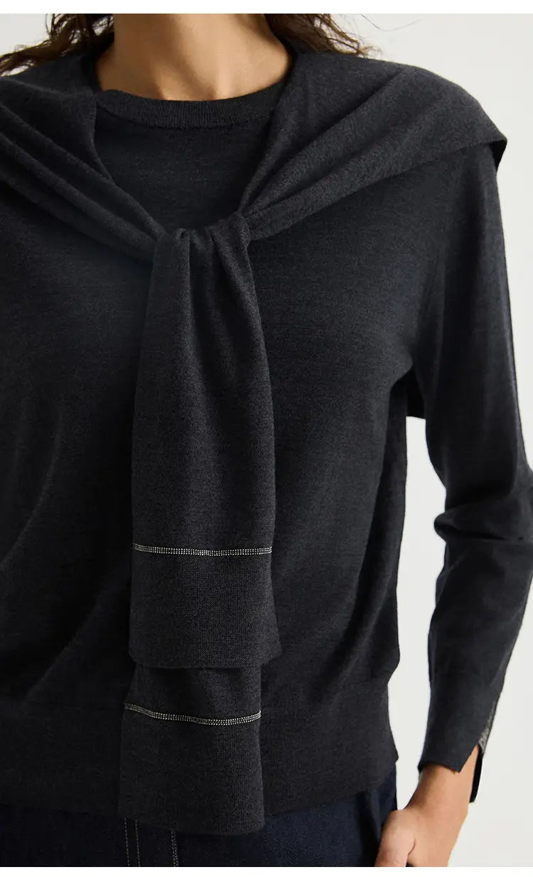 Schwarzer Wollstrick-Schulterwickel-Cape-Schal mit drapiertem gebundenem Halsausschnitt und dezentem horizontal geripptem Detail an den Bündchen.