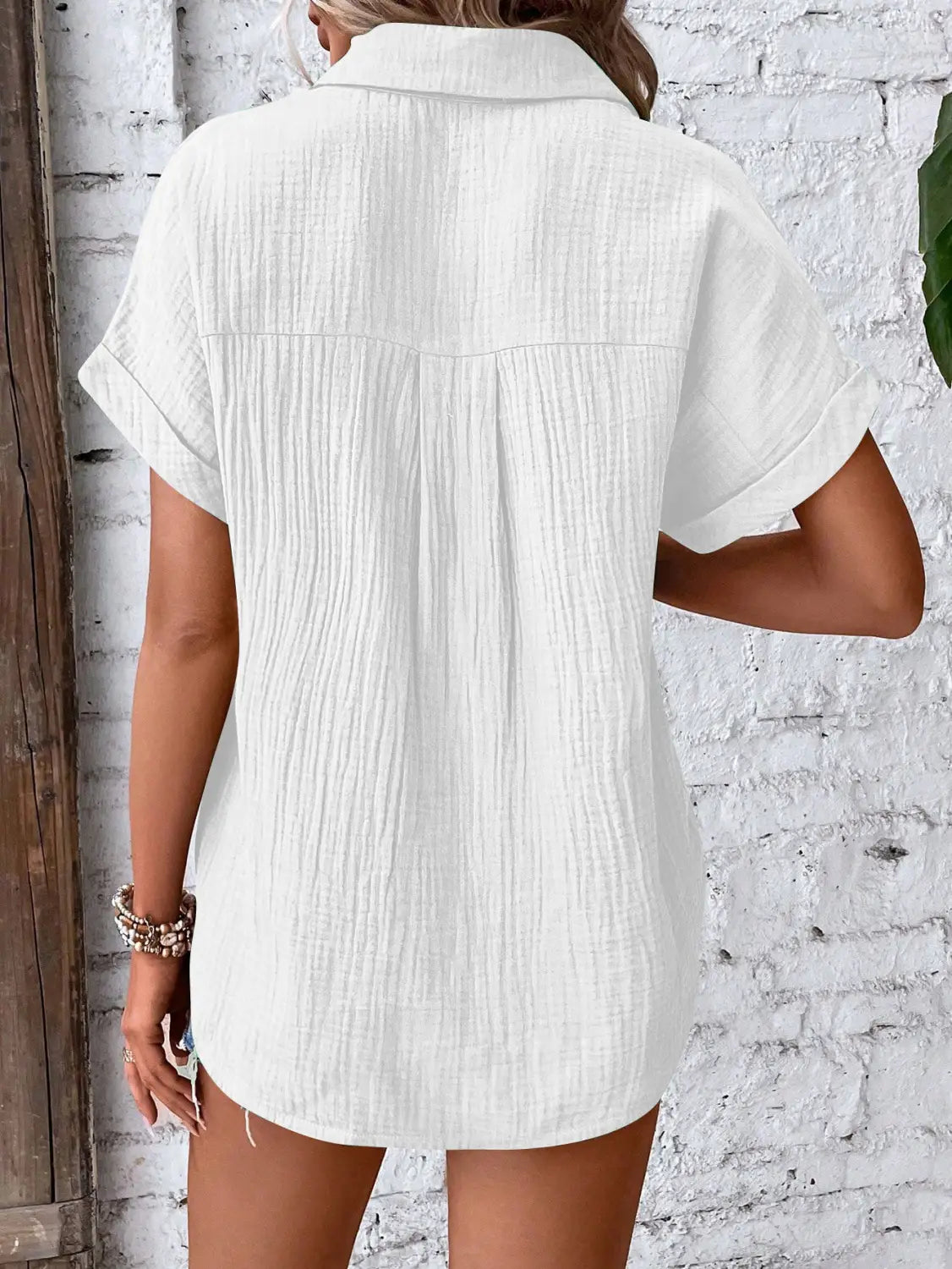 White women cotton short sleeve button up shirt dress with subtle textured fabric and collar.