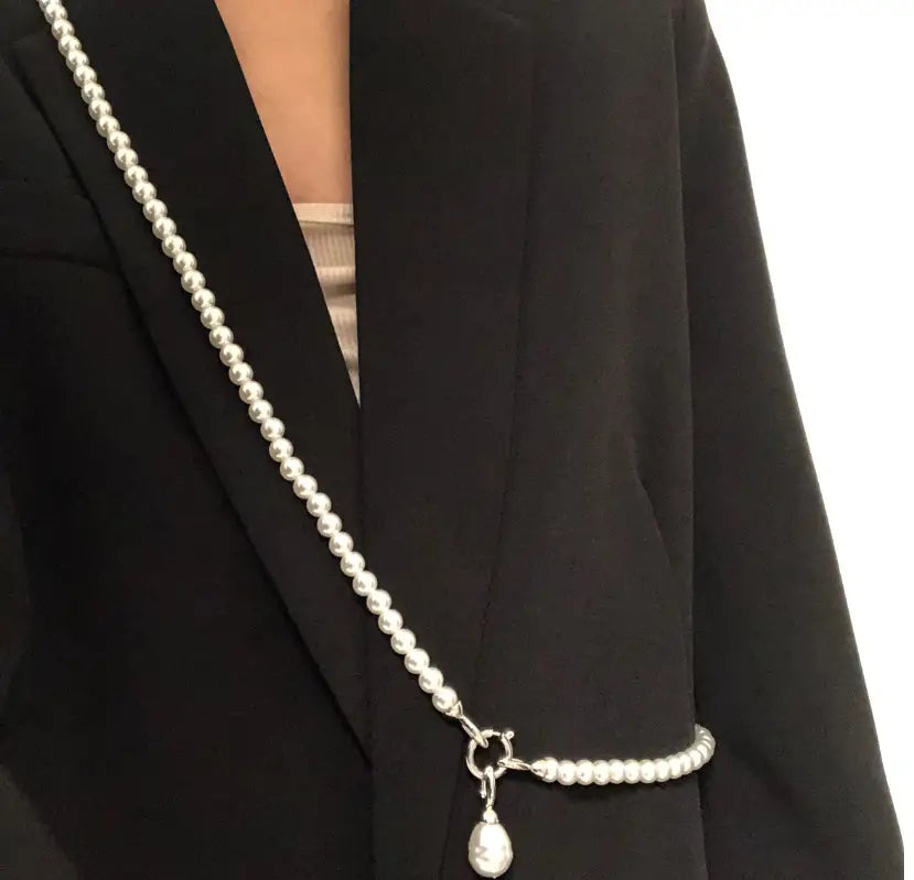 Un long collier en pendentif de perles à perles argentées, élégant, pour femmes, avec des perles de taille uniforme et un pendentif en forme de goutte doté d’une fermeture métallique polie.