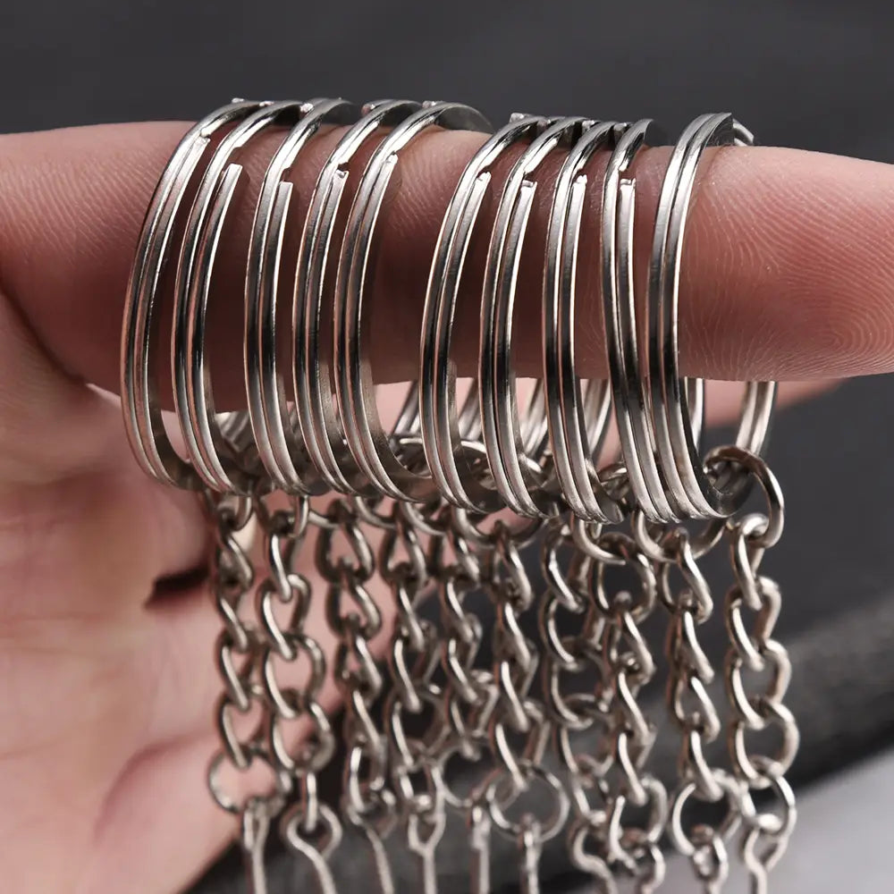 A set of silver-toned metal keychains with split rings and matching chain links dangling below.