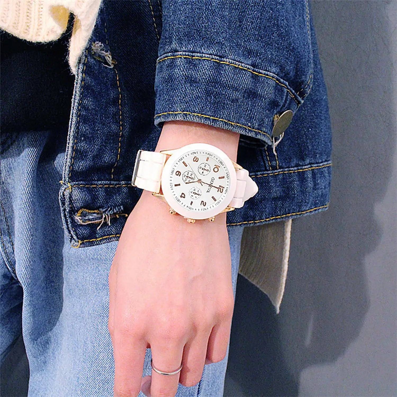 White ceramic women silicone quartz fashion chronograph watch with gold-tone accents and minimalist dial worn on a wrist