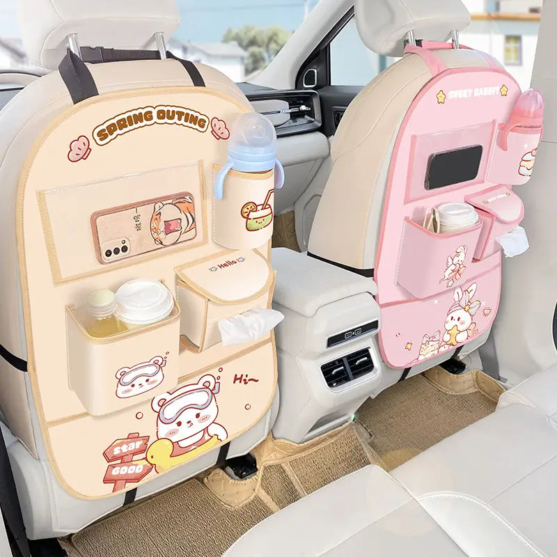 Organizadores para el asiento trasero del coche con temática de dibujos animados en tonos beige y rosa, con múltiples bolsillos, portabotellas integrado y diseños adorables de animales para el almacenamiento y la organización del vehículo.