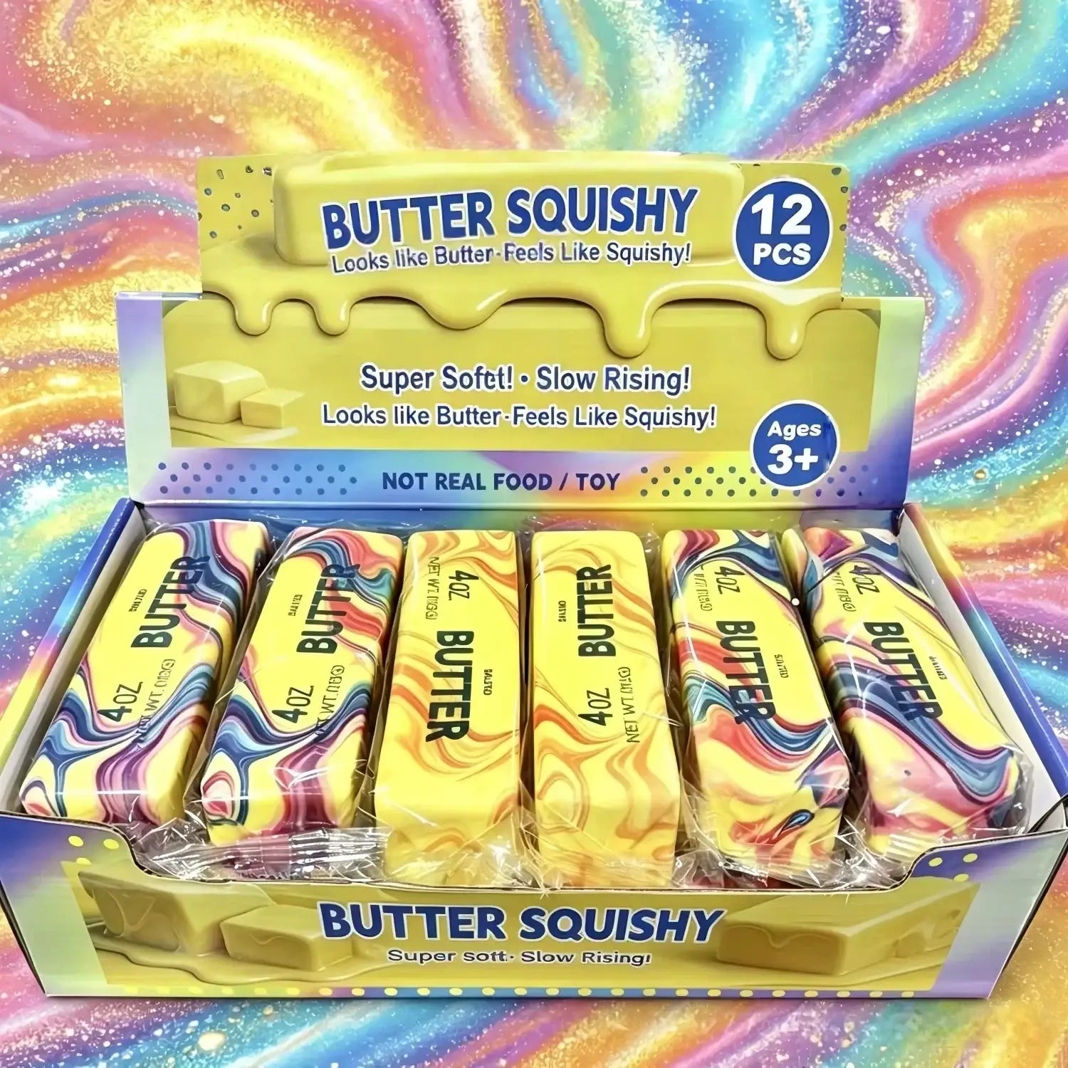una vista frontal de juguetes “squishy” con forma de barra de mantequilla amarilla y marmoleados de varios colores, dentro de una caja rotulada “butter squishy” para aliviar la ansiedad y para el uso de barra de mantequilla