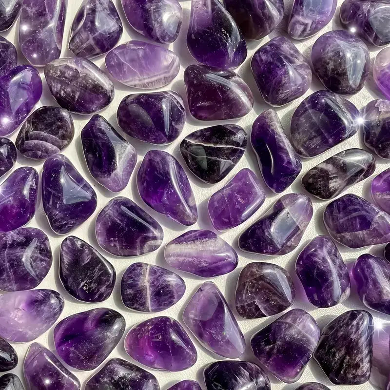 Pierres roulées naturelles d’améthyste pesant 100 g, avec des surfaces lisses et polies et des motifs naturels de bandes pourpres, utilisées pour des soins de reiki.