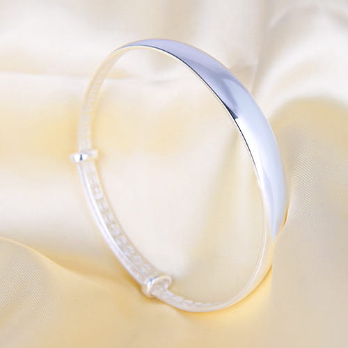 A sleek minimalist sterling silver round bangle bracelet for women with a smooth polished finish and an adjustable clasp.