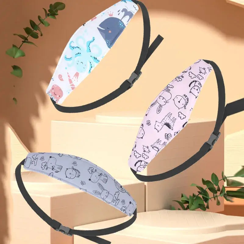 drei farbenfrohe Kopfstützriemen mit Cartoon-Muster für den Babyschalen-Sitz mit schwarzen elastischen verstellbaren Schnallen, ausgelegt als Schlafpositionierer.