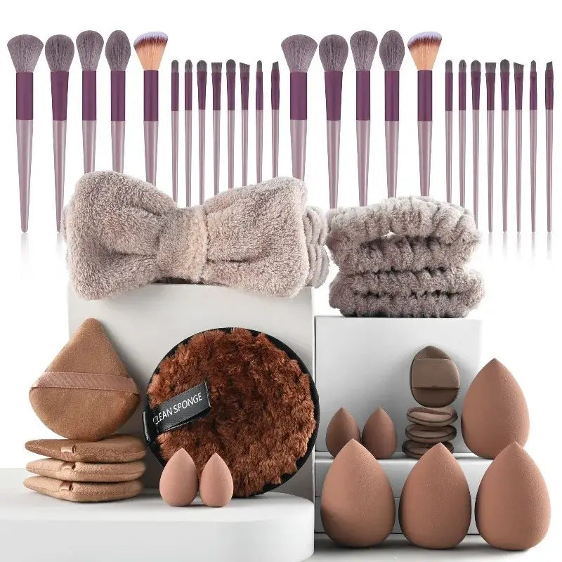 A plush beige bow-shaped headband with a soft fuzzy texture included in a 46 piece pink makeup brush and sponge set for makeup application and eye makeup application.