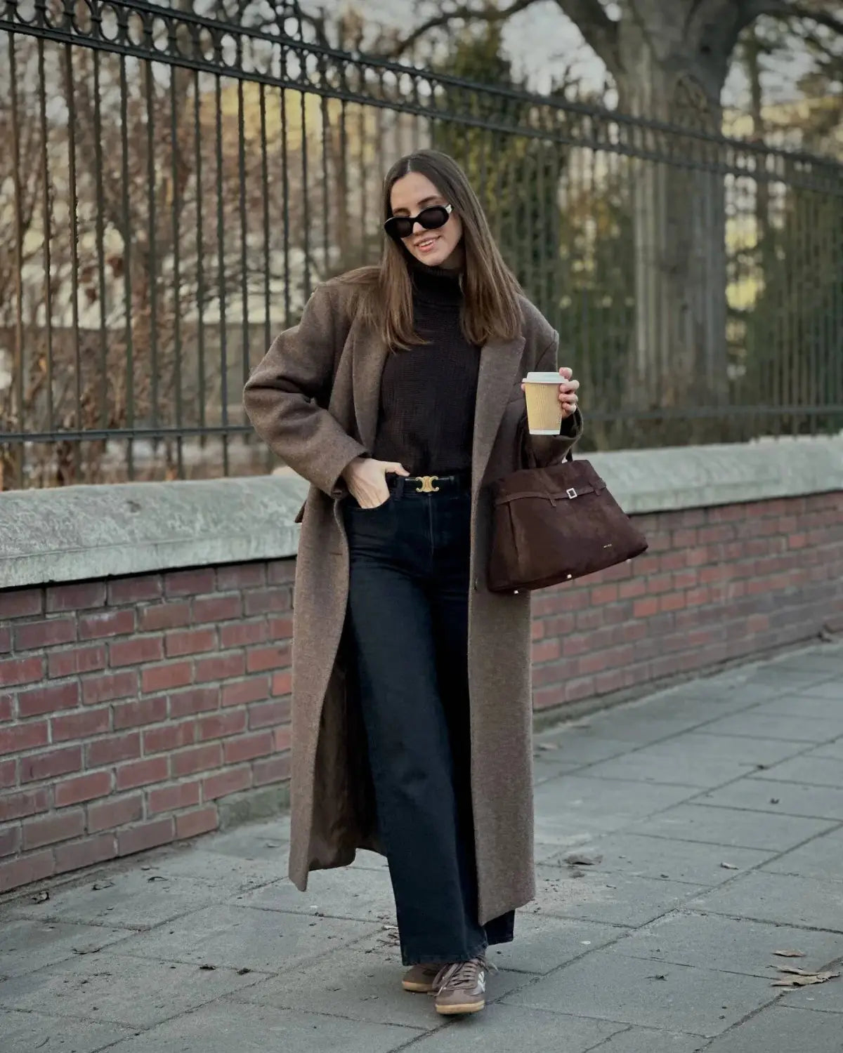 Brown leather handbag with a single top handle and a front flap closure complementing a brown wool blend overcoat for women winter commuter jacket.