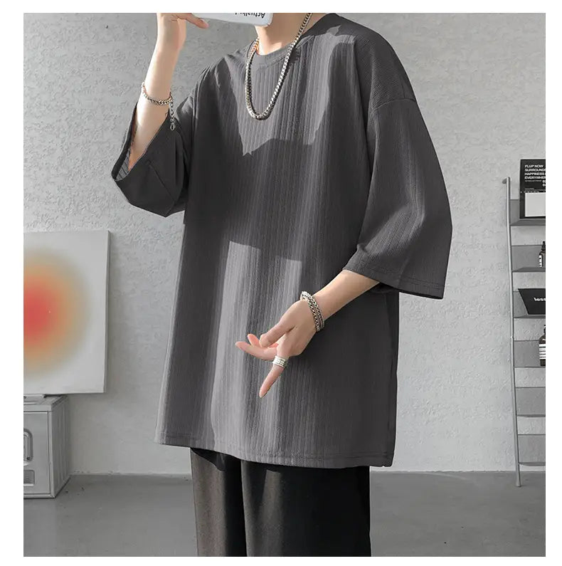 Dark gray loose-fitting men striped oversized summer t shirt with three quarter sleeves and subtle vertical ribbing.